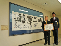 「山上軍艦」　感謝状を持つ山本飛雲さん（左）と古賀区長（右）写真