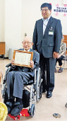 表彰式で福田定（左）さんと高松八幡東区長（右）写真