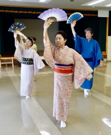 楠橋クラブのクラブ生たちが、扇を持って舞っています。