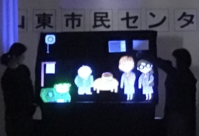 パネルシアター画像1:部屋を暗くし、光る人形で劇をしています。