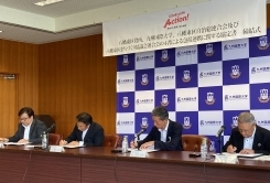 協定書へ自筆する様子