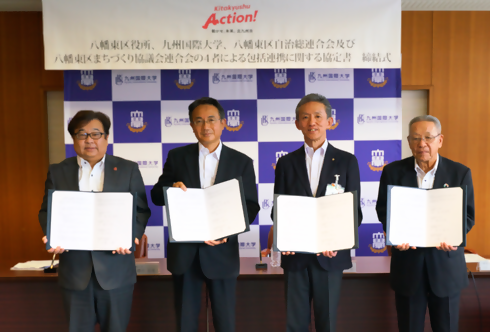 協定書を手に写真撮影に応じる締結者