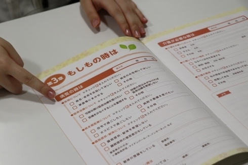 テーブルの上で「私のこれからノート」を開く手元