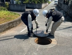 マンホールをあけて一次調査する職員の様子