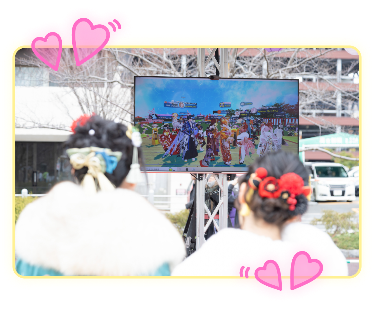 着物を着た女性たちが、大きなモニターを見ている