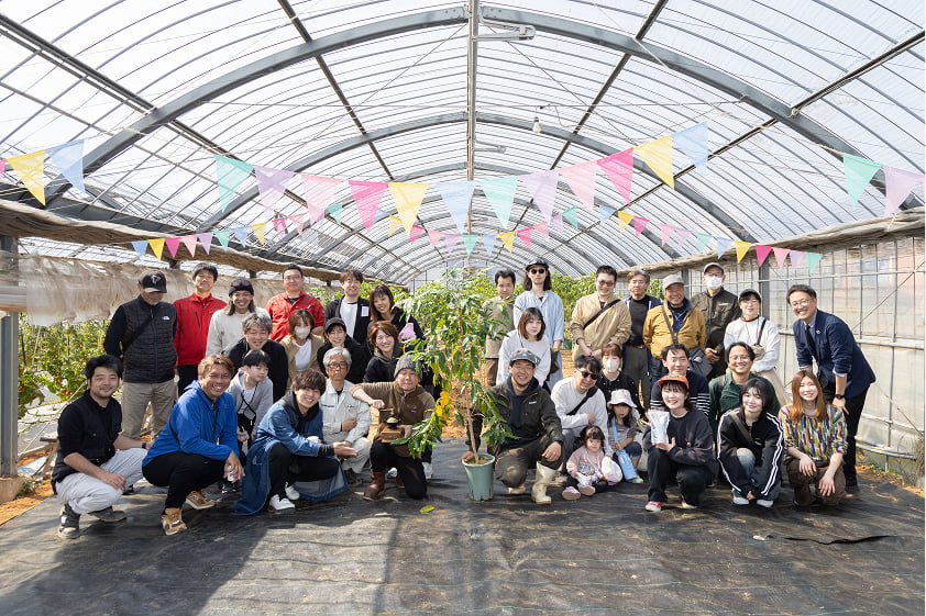 ビニールハウスの中で、大勢での記念撮影