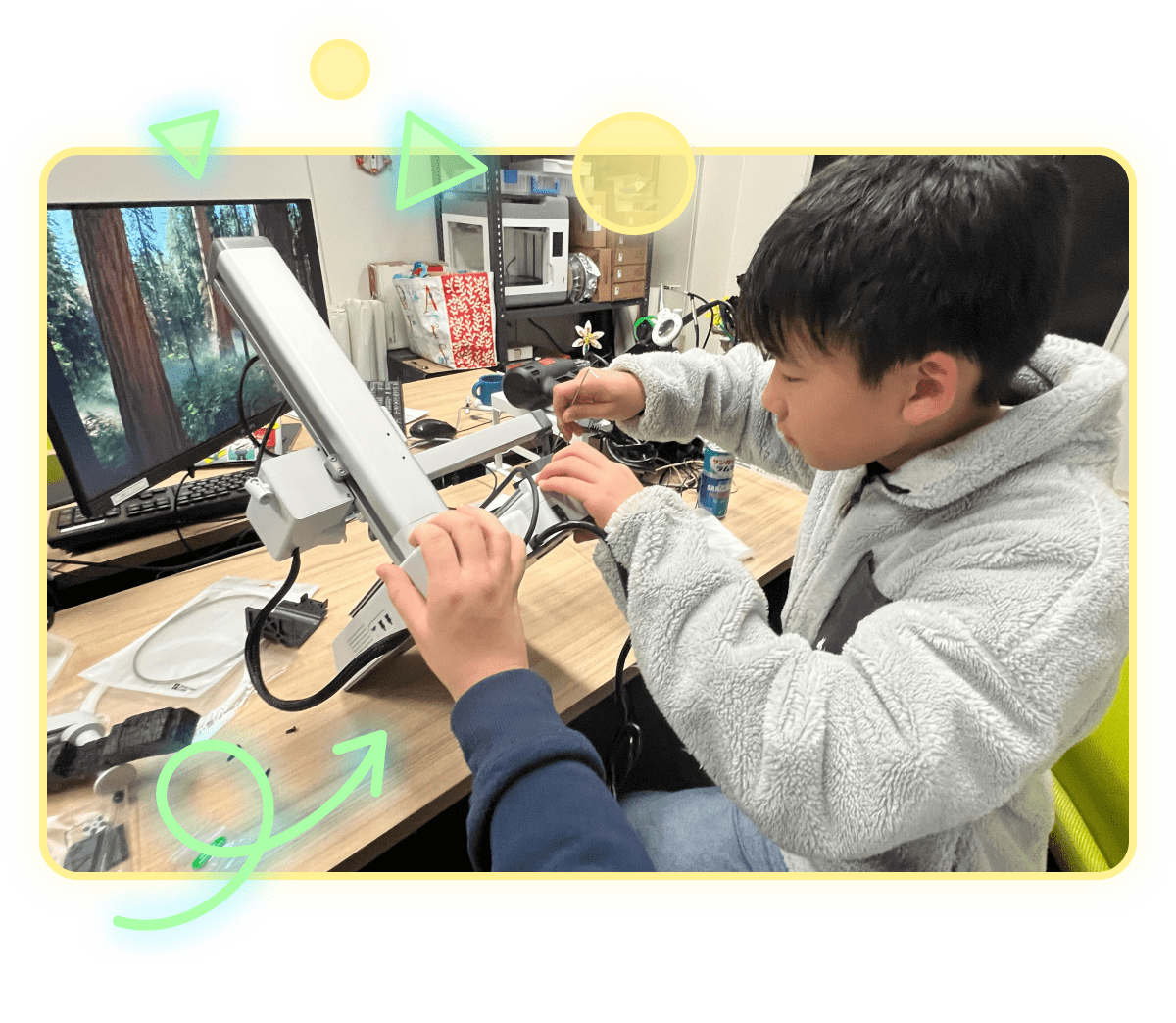 パソコンの前で、機械をさわっている男性